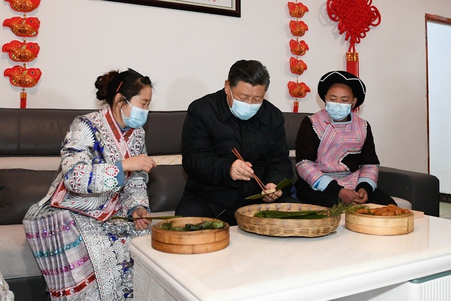 2021年2月3日下午，習近平在貴州畢節(jié)市黔西縣新仁苗族鄉(xiāng)化屋村苗族村民趙玉學家，同一家人邊聊家常邊制作當?shù)貍鹘y(tǒng)節(jié)日食品黃粑。新華社記者 李學仁 攝