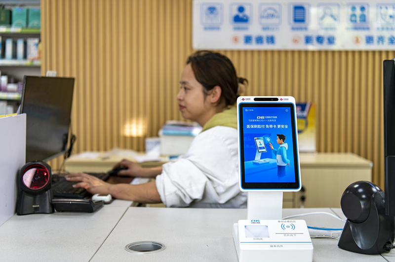 2024年4月10日，浙江金華市區(qū)一家民眾大藥房柜臺(tái)上設(shè)置著醫(yī)?！八⒛樦Ц丁睓C(jī)器，群眾看病更加便利。